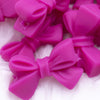 Close up view of a pile of 27mm Hot Pink Bow Knot silicone bead