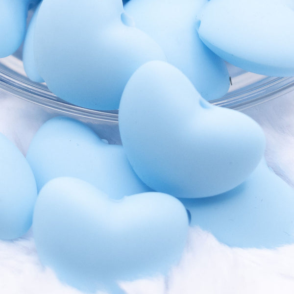 Close up view of a pile of 20mm Light Blue heart silicone bead