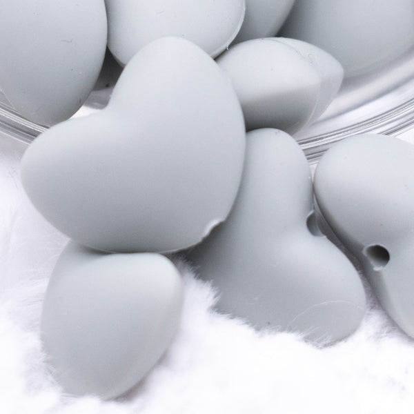 Close up view of a pile of 20mm Light Gray heart silicone bead
