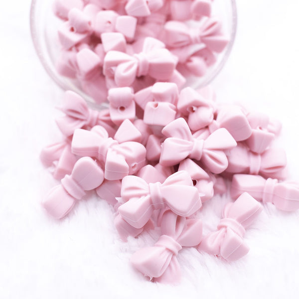 Front view of a pile of 27mm Light Pink Bow Knot silicone bead