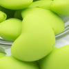 Close up view of a pile of 20mm Lime Green heart silicone bead