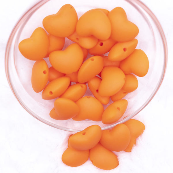 Top view of a pile of 20mm Orange heart silicone bead