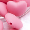 Close up view of a pile of 20mm Pink heart silicone bead