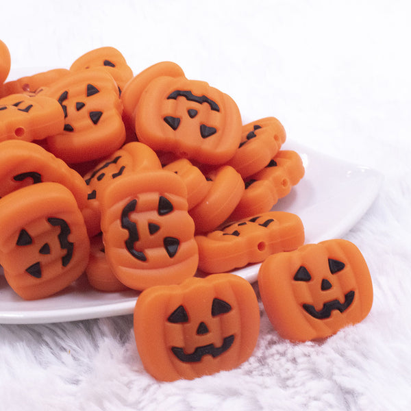 front view of a pile of Pumpkin Silicone Focal Bead Accessory - 30mm x 27mm