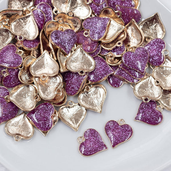 Top view of a pile of Purple Glitter Enamel Heart Charm 15mm