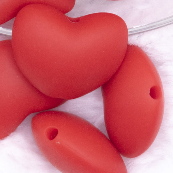 Close up view of a pile of 20mm Red heart silicone bead