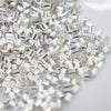Close up view of a pile of 2mm Silver Crimp Tubes for Jewelry Making