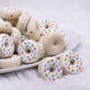front view of a pile of Donut with White Icing and Sprinkles Silicone Focal Bead Accessory - 28mm