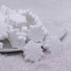 front view of a pile of White Snowflake Silicone Focal Bead Accessory - 28mm x 28mm