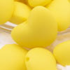 Close up view of a pile of 20mm Yellow heart silicone bead