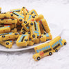 front view of a pile of Yellow School Bus Silicone Focal Bead Accessory - 18mm x 30mm