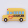 top view of a pile of Yellow School Bus Silicone Focal Bead Accessory - 18mm x 30mm