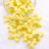 Front view of a pile of 27mm Yellow Bow Knot silicone bead